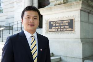 Matthew Jiang stands in front of the Executive Office of the Mayor building where he had an internship