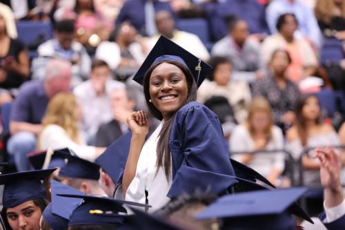 A student smiling among the crowd at a CCAS Celebration Ceremony